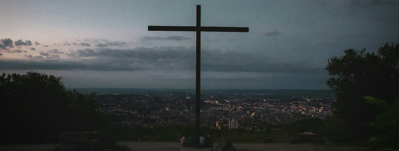 Croix au crépuscule au-dessus d’une ville